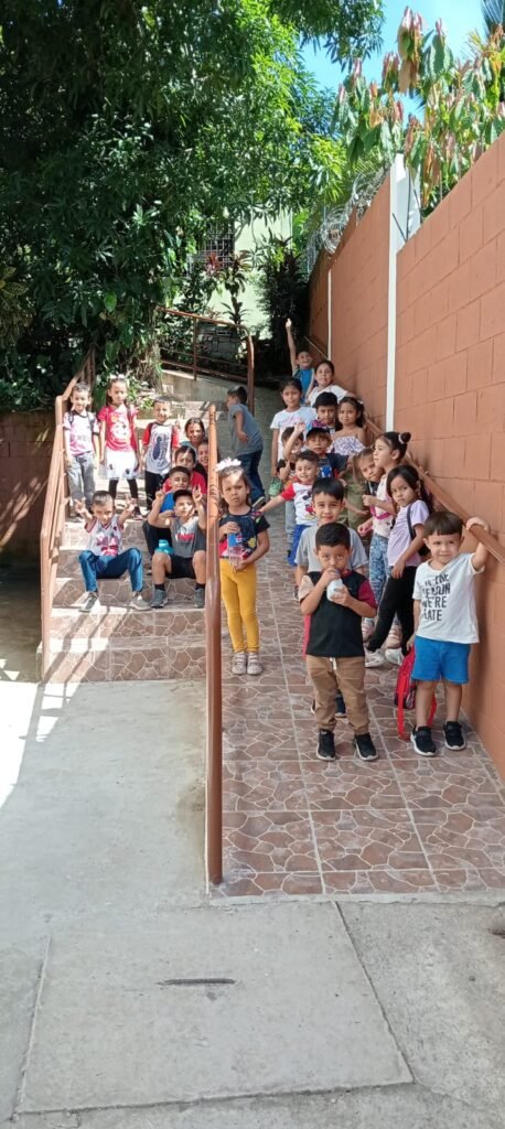 Un grupo de niños bajando por las escaleras de la iglesia bautista, mostrando entusiasmo y alegría mientras regresan de una actividad.