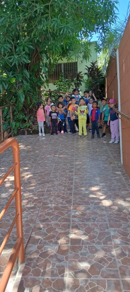 Un grupo de niños subiendopor una rampa, jugando y riendo mientras caminan hacia la iglesia bautista.
