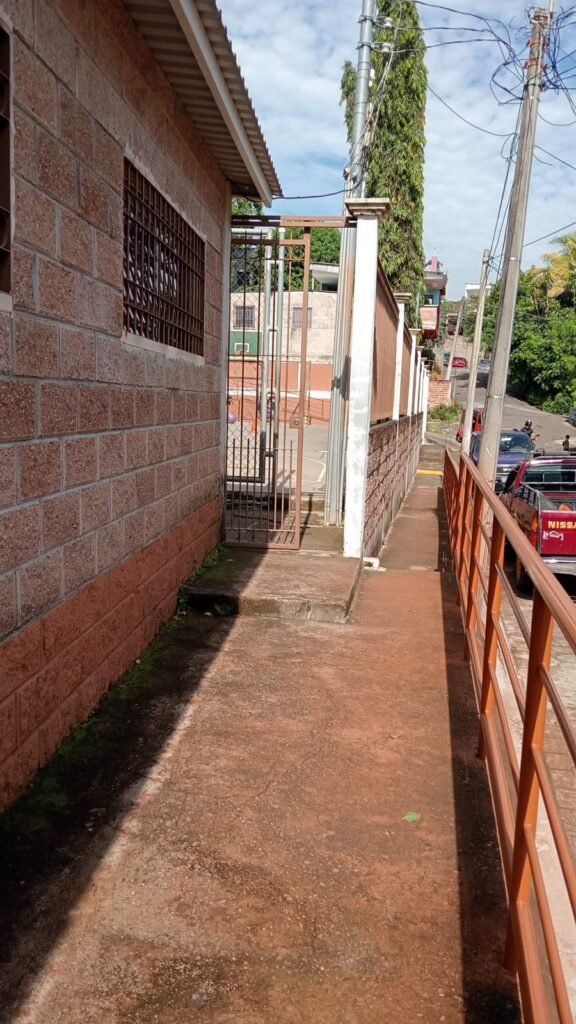Una entrada a un camino adyacente, con una puerta abierta que conduce hacia la preparación de eventos en la iglesia bautista.